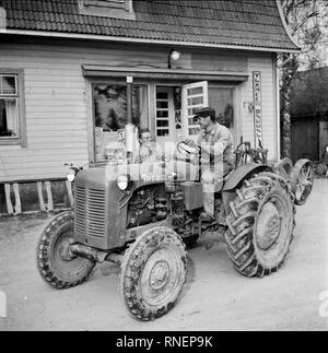 Finland History -  A Finnish Farmer works with a tractor at the Yllänen Osuusliikkeen Rannanmäki store. ca. 1955 Stock Photo