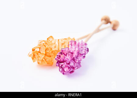 Rock candy or orange and purple sugar candy isolated on white background. Crystallized sugar. Nabat or rock candy is often used as a type of candy, or Stock Photo