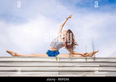 Ballerina doing the splits on the steps Stock Photo