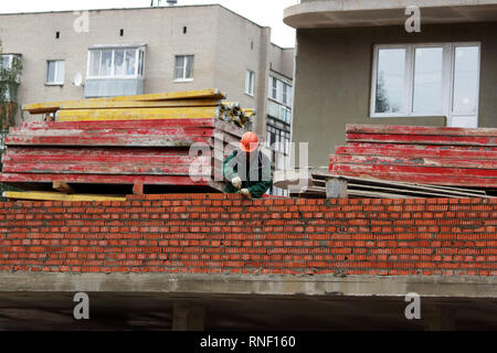professional construction worker laying bricks and building house on industrial site. Stock Photo