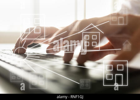 Online real estate concept - male hands typing on computer keyboard with house shaped icons over the image. Stock Photo