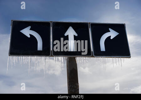 Traffic left right straight arrow sign with icicles cold weather in Toronto, Ontario, Canada. Stock Photo