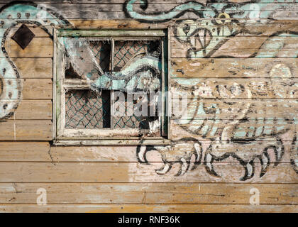 The side of an old and abandoned gypsy caravan with a dragon painting on the side of it, on the shores of Loch Ness, Scotland Stock Photo