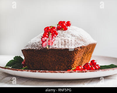 Chocolate cake, fresh berries, vintage plate on a white background. Side view, close-up. Concept of tasty food Stock Photo
