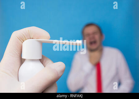 Doctor holds spray medicine for sore throat, in the background a man who has a sore throat and sore throat, medicament Stock Photo