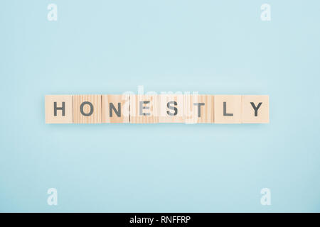 top view of honestly lettering made of wooden cubes on blue background Stock Photo