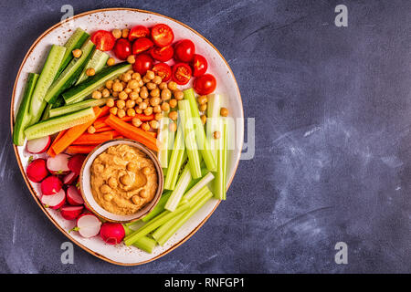 Hummus with various fresh raw vegetables, top view. Stock Photo