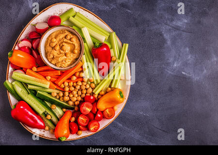 Hummus with various fresh raw vegetables, top view. Stock Photo