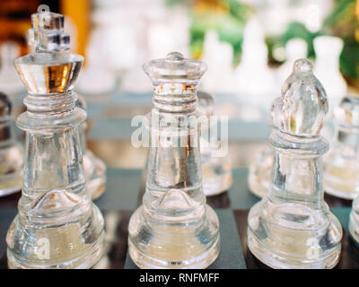 Close up of transparent chess pieces, King, Queen and Bishop on chess board Stock Photo