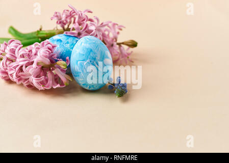 pink hyacinth and painted eggs on beige Stock Photo