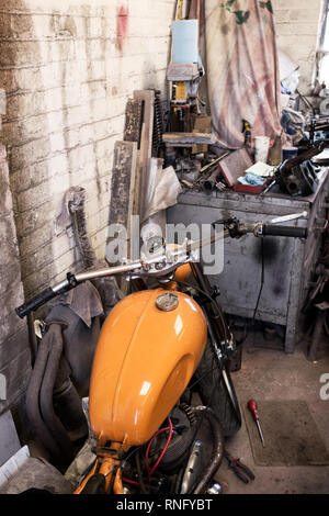 Interior view of local motorcycle workshop garage full of various motorbikes and spare parts under repair Stock Photo