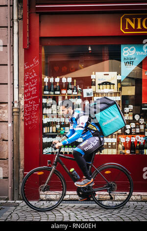 Strasbourg, France - Oct 1, 2017: Side view of young Deliveroo biker wearing cycling branded outfit pedaling fast. The online food delivery company was founded in 2013 by Will Shu and Greg Orlowski Stock Photo