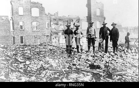 Soldiers from the Presidio stand amid the rubble of fallen buildings after the earthquake.  The Hall of Records (dome) is in the background (right). Stock Photo