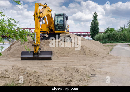 excavator loader machine during earthmoving works outdoors at construction site. Stock Photo