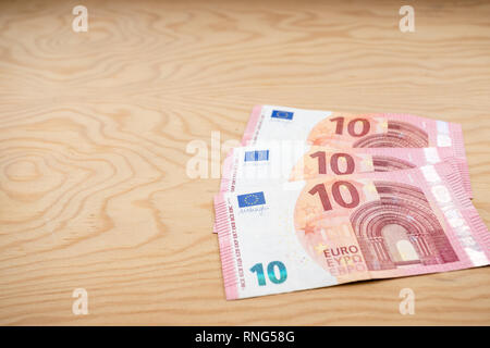 10 Euros notes fanned out on a light wood background. Stock Photo