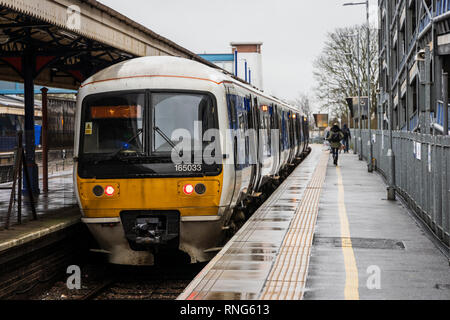 Commuters are running on a platform to a Chiltern Railways train from High Wycombe station to London during rush hour on a rainy winter morning Stock Photo