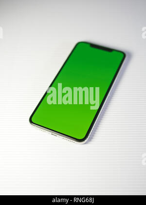 PARIS, FRANCE - SEP 27, 2018: Detail of new Apple Computers iPhone Xs Max as hero object on white background - smartphone telephone with OLED display with green chroma key screen Stock Photo