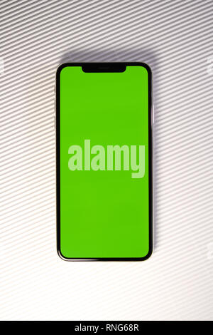PARIS, FRANCE - SEP 27, 2018: Detail of new Apple Computers iPhone Xs Max as hero object on white background - smartphone telephone with OLED display with green chroma key screen on stripe background Stock Photo
