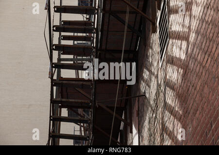 Fire escape stairs and ladder, in metal, on a typical North American old brick building from Montreal, Quebec, Canada. These stairs, made for emergenc Stock Photo