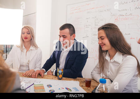 Handsome businessman with his two female architects smiling and discussing a project. Stock Photo