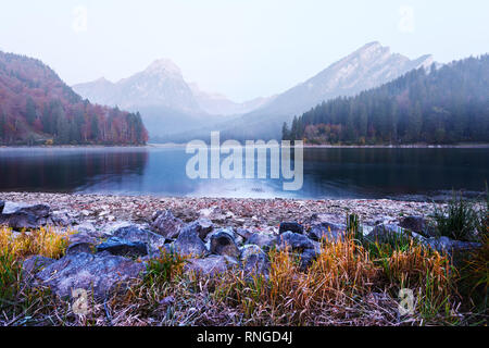 Peaceful autumn view on Obersee lake in Swiss Alps. Frosty grass and mountains reflections in clear water. Nafels village, Switzerland. Landscape photography