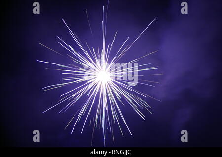 Bright white fireworks exploding in the night sky Stock Photo