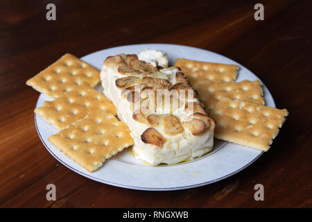 delicious garlic and cheese dip and cookies with wooden background Stock Photo