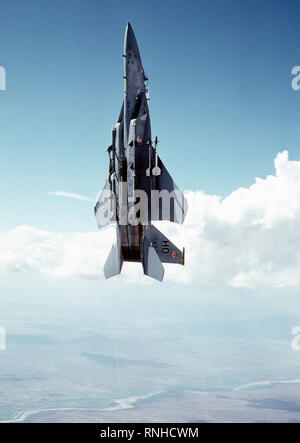 1980 - An air-to-air low angle left view of an F-15 Eagle aircraft in a vertical climb over the White Sands Missile Range at Holloman Air Force Base.  Two AIM-9 Sidewinder missiles are mounted on each wing and two AIM-7 Sparrow missiles are on each side of the fuselage Stock Photo