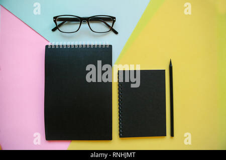 Glasses, notebook and pencil on a colorful background. Stock Photo