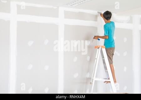 worker male on stair is putting  gypsum plaster interior decoration of home wall Stock Photo