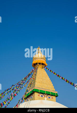 Buddhist prayer flags strung up from the dome and gold spire of Bodhnath Stupa, Kathmandu, Nepal Stock Photo
