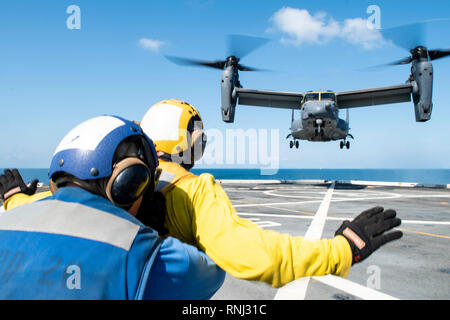 190218-N-DX072-1573 GULF OF THAILAND (Feb. 18, 2019) – Aviation Boatwain’s Mate (Handling) 3rd Class Walter Rutherford, from Cheyenne, Wyo., signals to a CV-22 Osprey helicopter, assigned to the 353rd Special Operations Group, as it lands on the flight deck of the amphibious transport dock ship USS Green Bay (LPD 20). Green Bay, part of the Wasp Amphibious Ready Group, with embarked 31st Marine Expeditionary Unit (MEU), is in Thailand to participate in Exercise Cobra Gold 2019. Cobra Gold is a multinational exercise co-sponsored by Thailand and the United States that is designed to advance reg Stock Photo