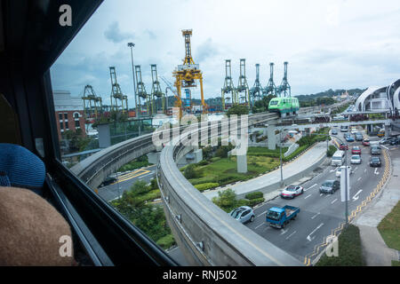 Singapore, Singapore - January 22, 2017: Window seat view of train rails passing over city traffic near Sentosa Island. Stock Photo