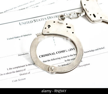 District Court criminal complaint, arrest warrant and search and seizure warrant doccuments with handcuffs isolated on white Stock Photo