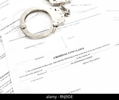 District Court criminal complaint, arrest warrant and search and seizure warrant doccuments with handcuffs isolated on white Stock Photo