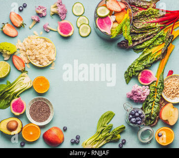 Healthy smoothie ingredients on light table, top view, frame. Various fruits , vegetables and berries with almond, chia seeds and pine nuts for tasty  Stock Photo