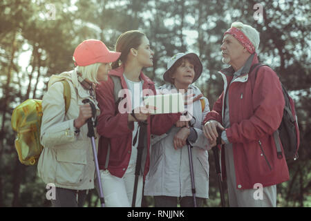 Tourists using GPS navigation on a tablet while hiking Stock Photo