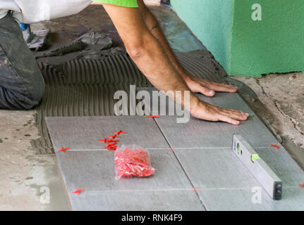 Worker installing floor tiles at home Stock Photo
