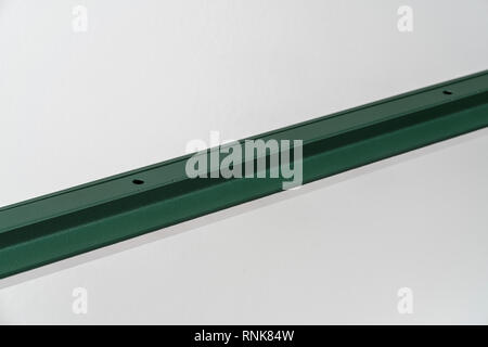 Good metal dark green LED lamp on the gray wall background indoors. Closeup horizontal photo. Stock Photo