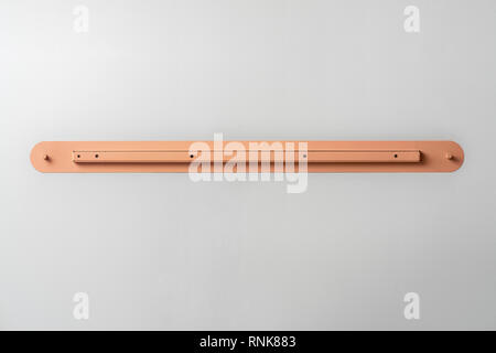 Nice metal orange lamp on the gray wall background indoors. Closeup horizontal photo. Stock Photo