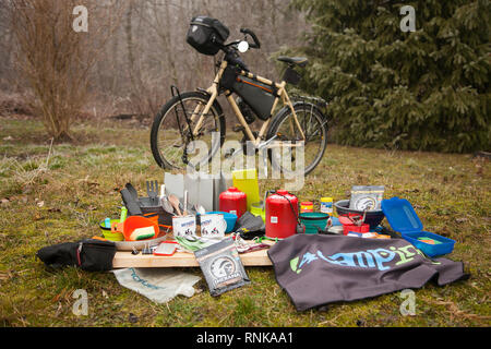 Person packing the bicycle panniers on a long cycle tour with family. A list of equipment. Stock Photo