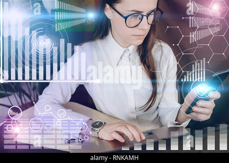 Woman in glasses working on a project in loft office. Woman develops marketing plan. Laptop and paperwork on the table. Statistic graph overlay, icon  Stock Photo