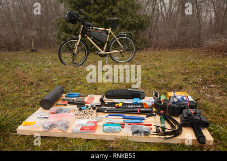 Person packing the bicycle panniers on a long cycle tour with family. A list of equipment. Stock Photo