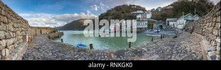 The historic little working fishing  harbour sits at the foot of the steep climb into the cobbled main street of Clovelly overlooking Bideford Bay in  Stock Photo