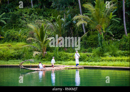 Balinese in traditional dress visit Tirta Taman Mumbal water temple and lake to celebrate a religious holiday. Stock Photo