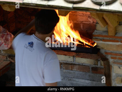 Young man stands in front of barbecue bricks grill Stock Photo