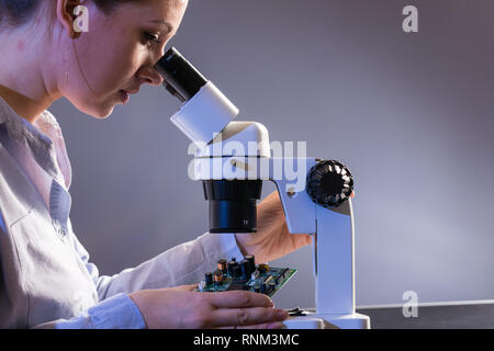 Young computer technician examining a printed circuit board. Microchip production factory. Stock Photo