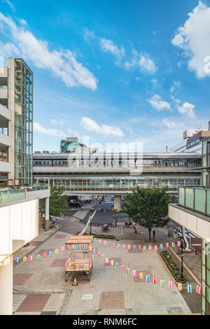 View of the square in front of the Nippori train station decorated for the Obon festival in the summer with a yagura tower and paper lanterns in the A Stock Photo