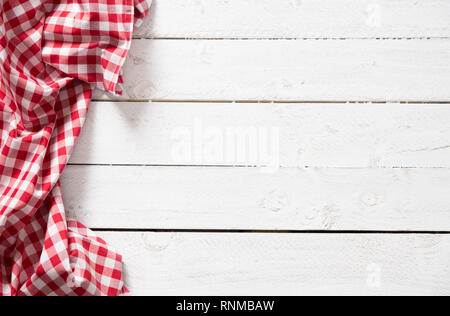 Red checkered kitchen tablecloth on wooden table. Stock Photo