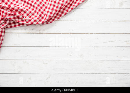 Red checkered kitchen tablecloth on wooden table. Stock Photo